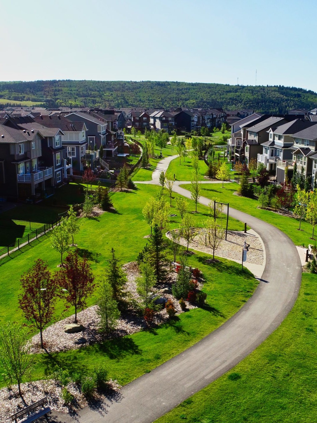 A multi-use path winds through the community of Sunset Ridge. The path is lushly landscaped, dotted with picnic tables and benches, and features bollard lighting for evening safety.
